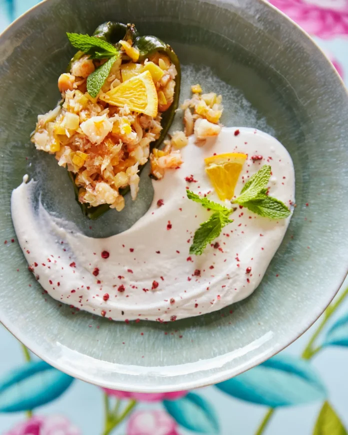 An above shot of a sea-green, light blue bowl filled with Seafood Stuffed Poblano Peppers.