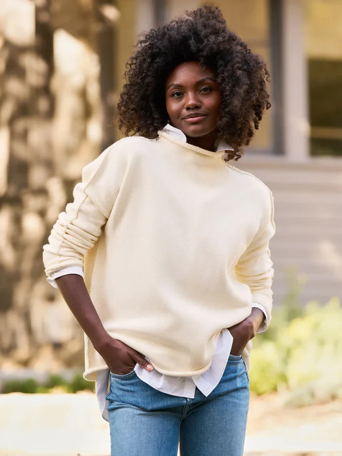 An oversized white knit sweater on a woman outside.