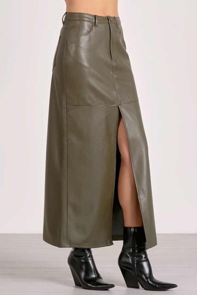 A woman in a long leather green skirt.