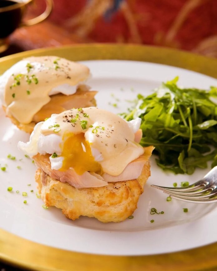 Smoked trout eggs benedict on biscuits with all-in-one hollandaise sauce and a side of fresh arugula.