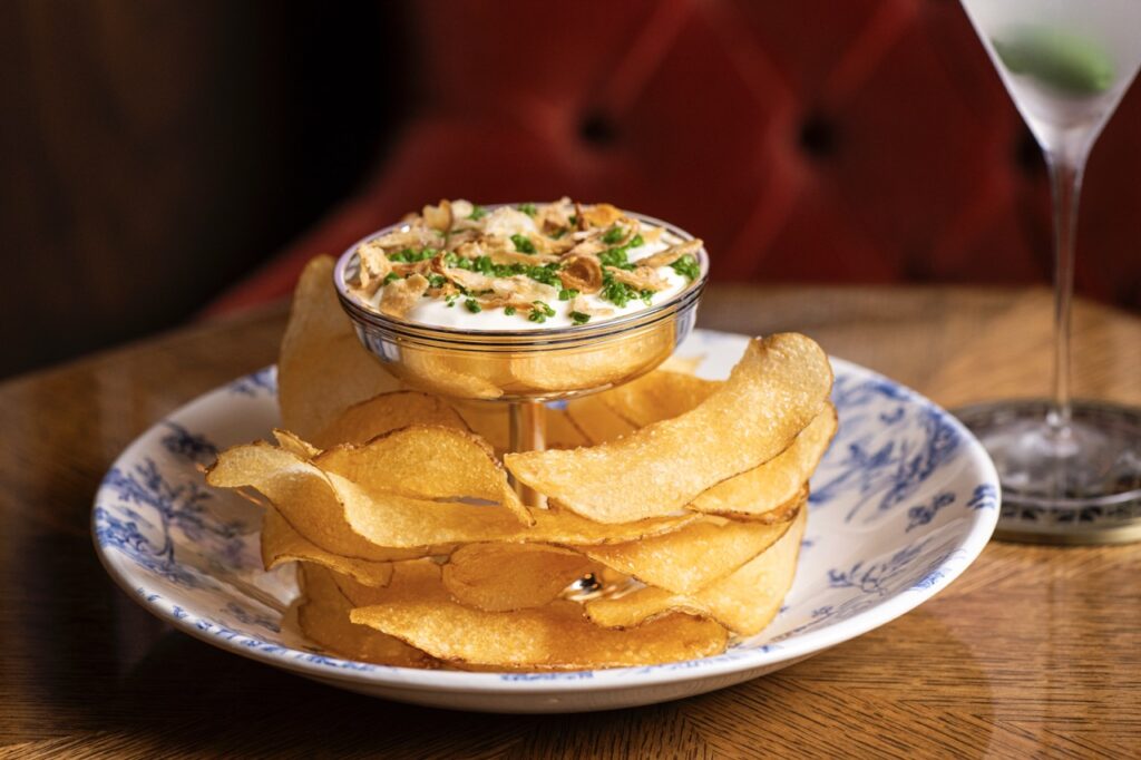 A plate of chips with french onion dip on a tower.