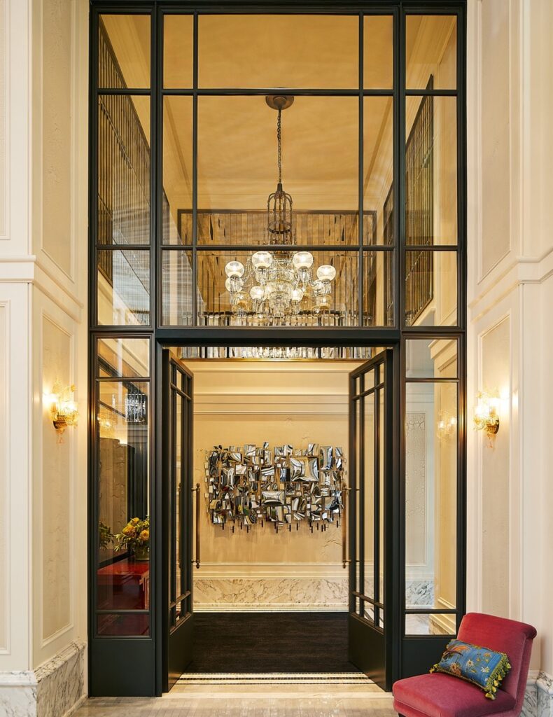 The outside door of Fifth Avenue Hotel with large windows.