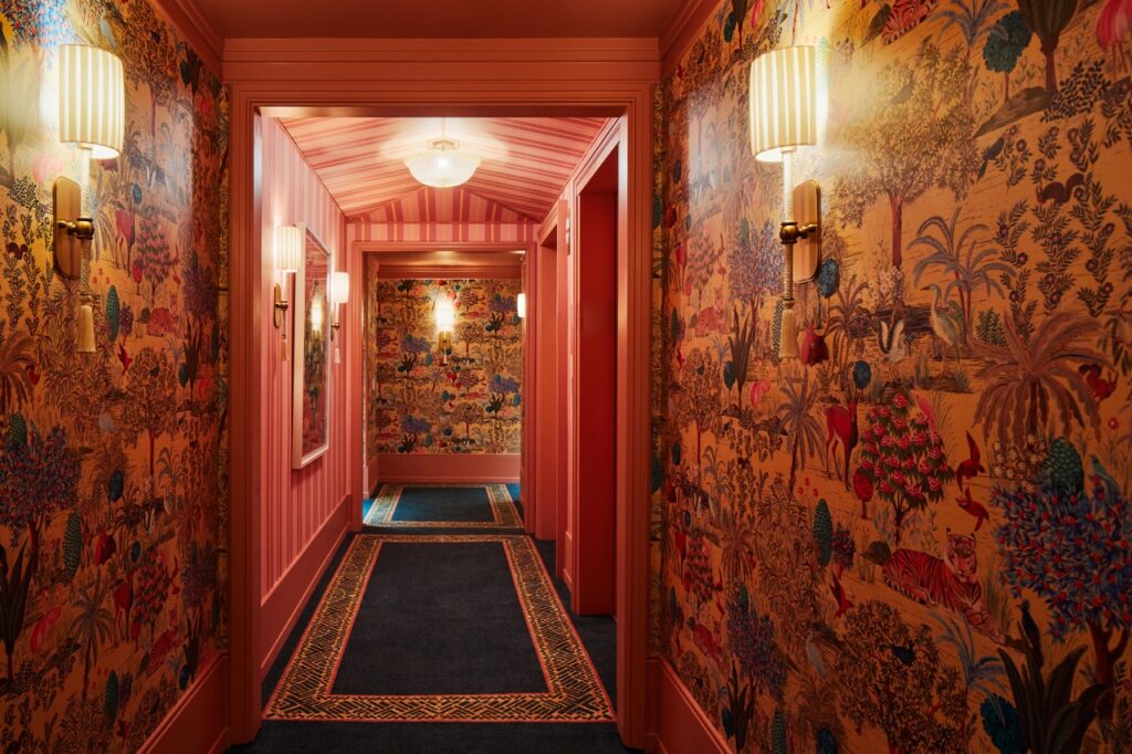 A red hallway plastered with art.