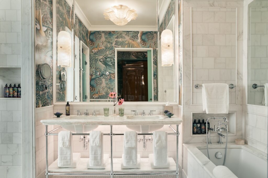 A luxury bathroom with floral walls and two sinks.