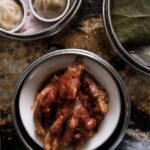 A bowl full of steamed ribs with dumplings sitting above it.