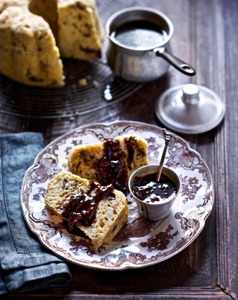A plate of dutch boffert with a small bowl of jam beside them.