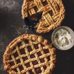 Two pies with fancy lattice work homemade pie crust.