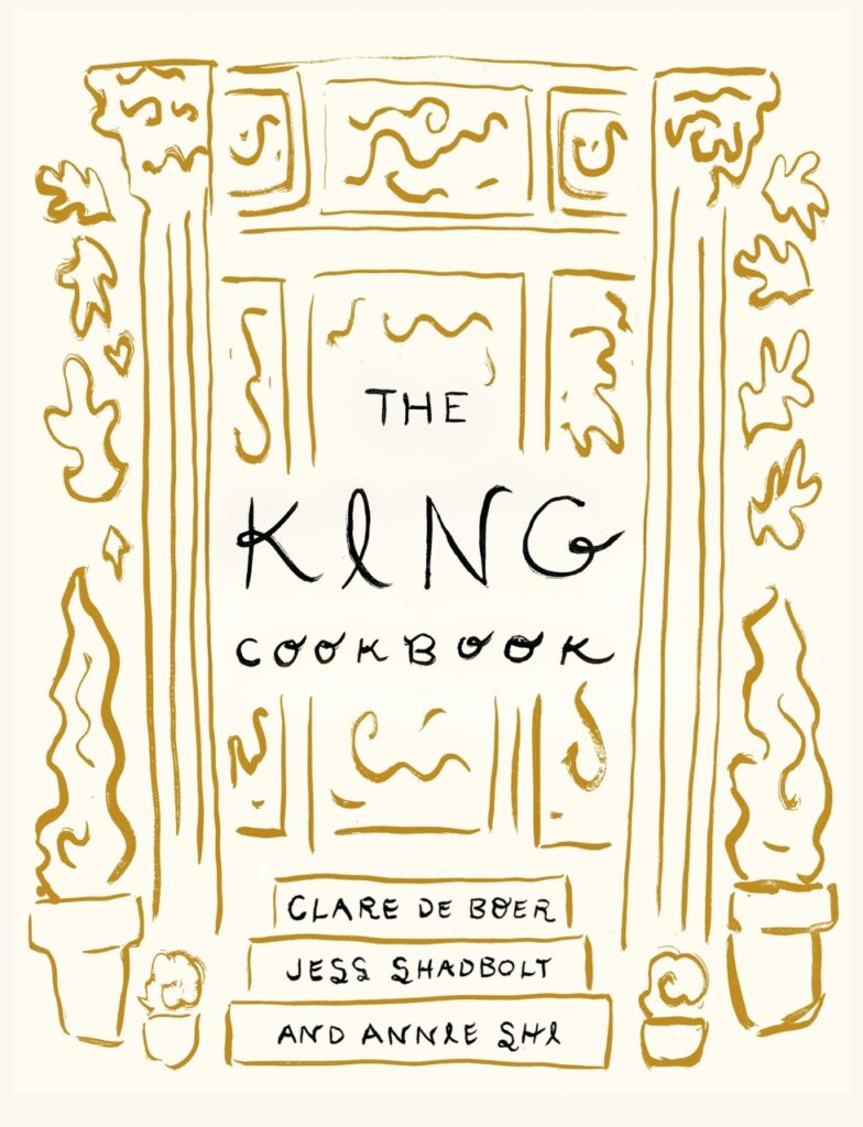 A cookbook cover with gold designs on it.