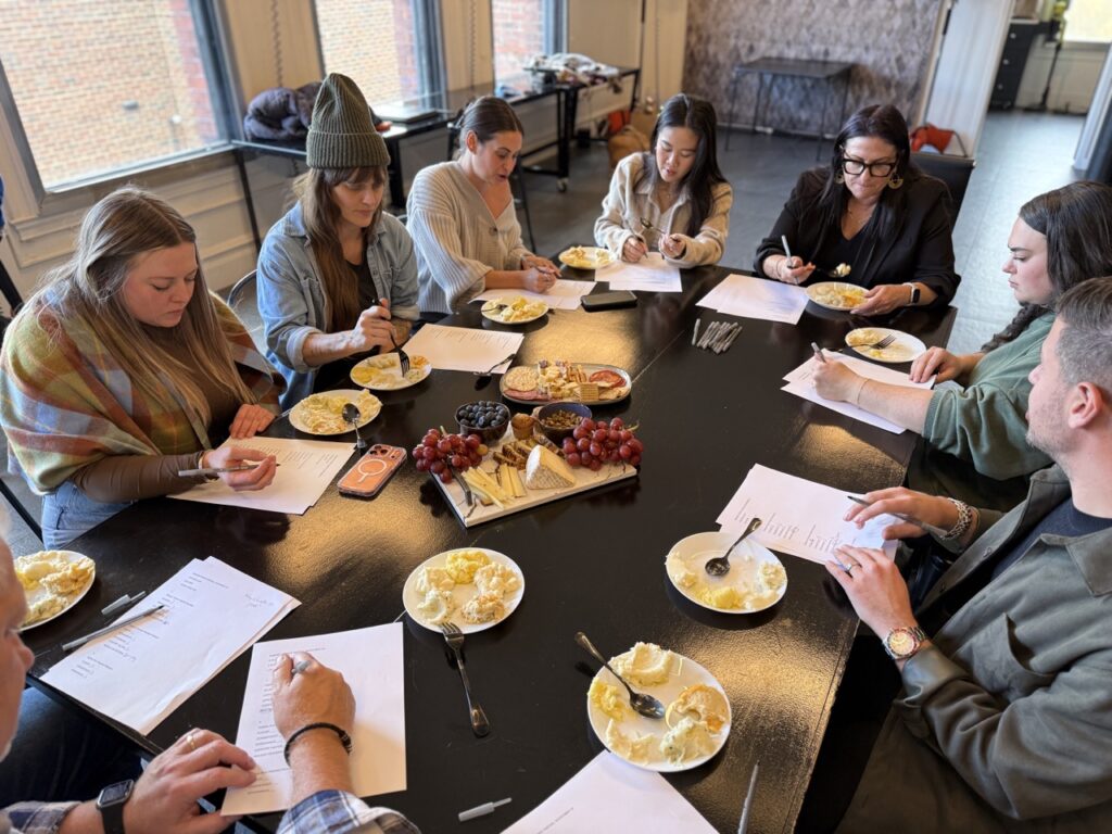 A group of people with plates of potatoes and papers at a table.