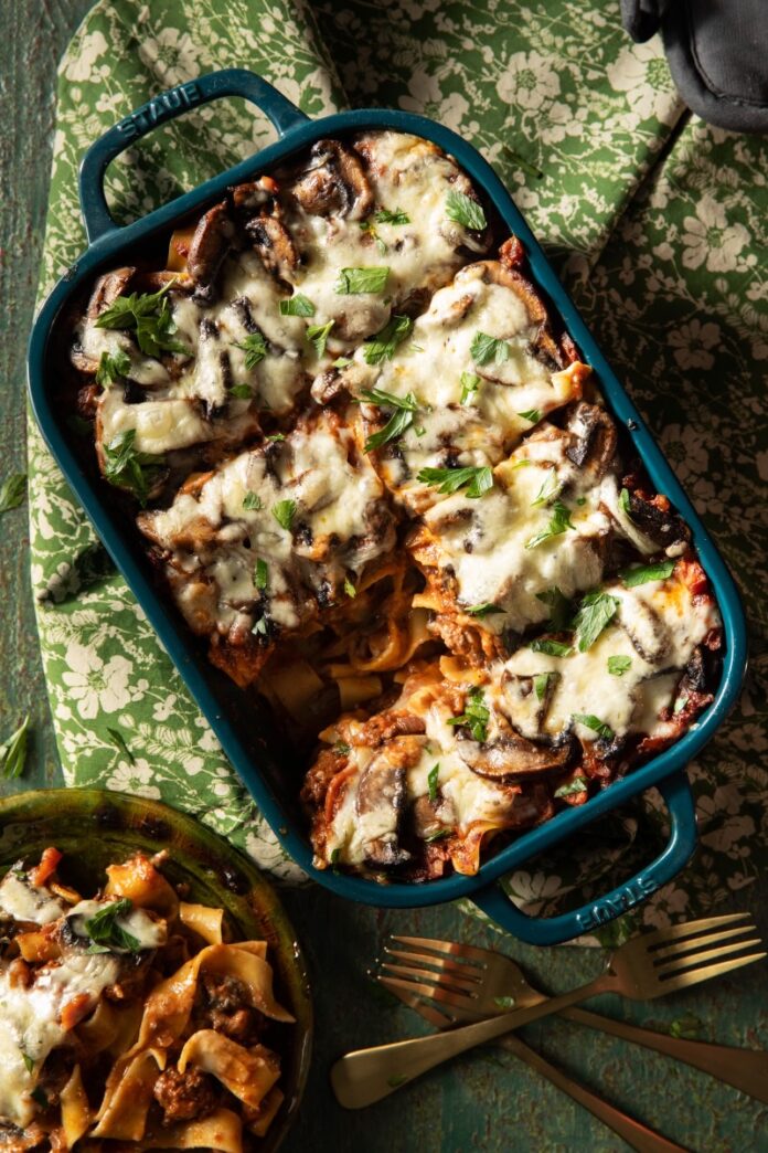 Wild Boar Pappardelle TABLE Magazine A pan of Wild Boar Pappardelle with a plate of a slice beside it.