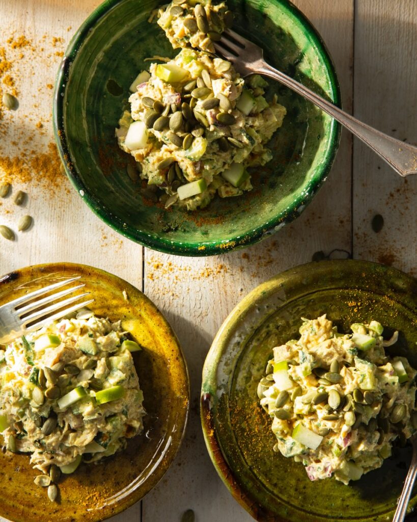 Three plates full of High Protein Chicken Salad with nuts on top.