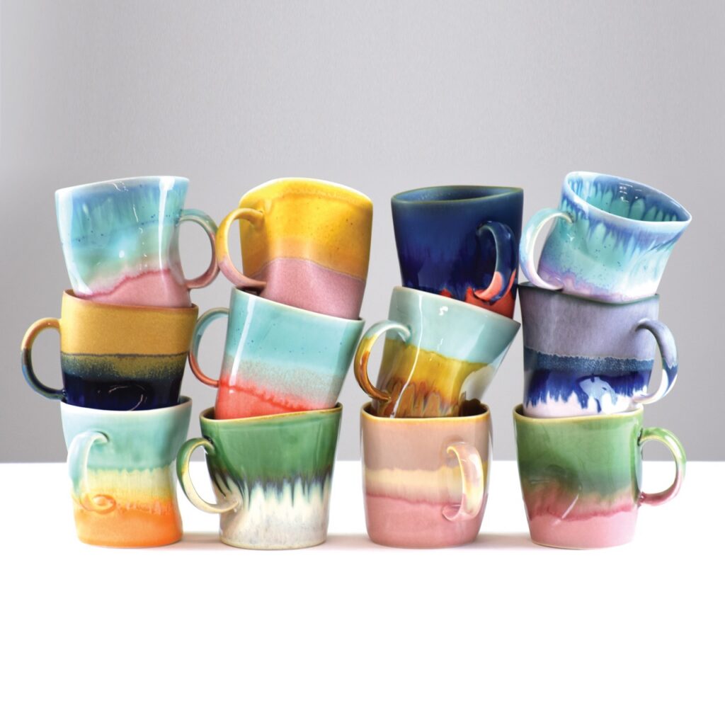 Four stacks of mugs with three colorful mugs in each.