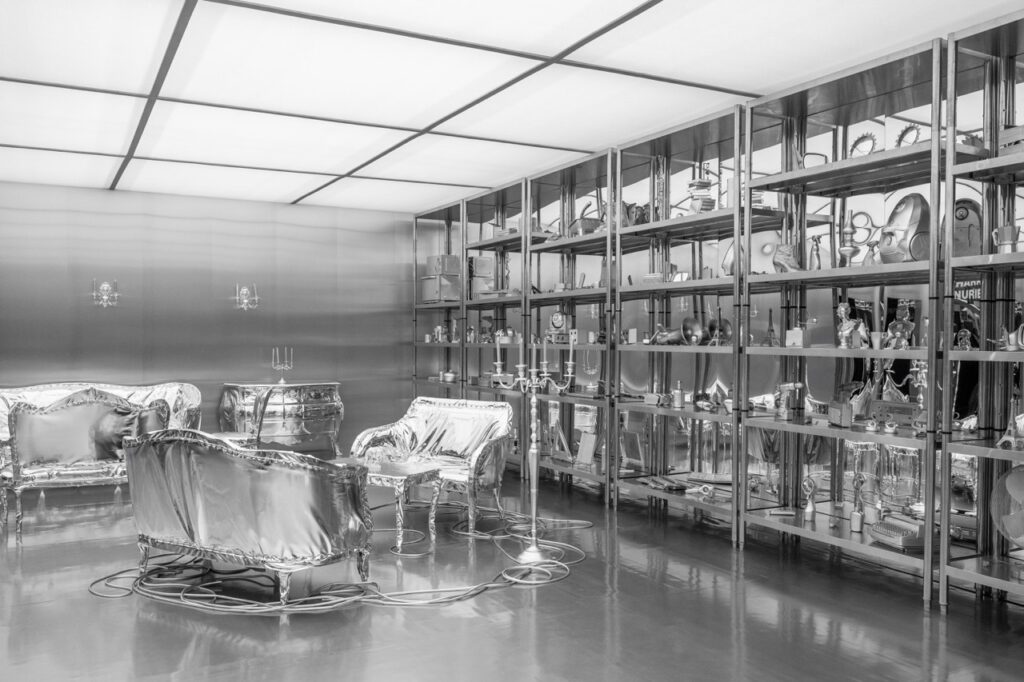A room of silver furniture like chairs and shelves of dining ware.