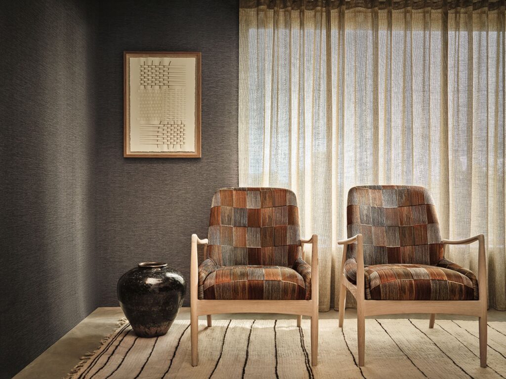 Two pattern block chairs sit in a grey living area space.