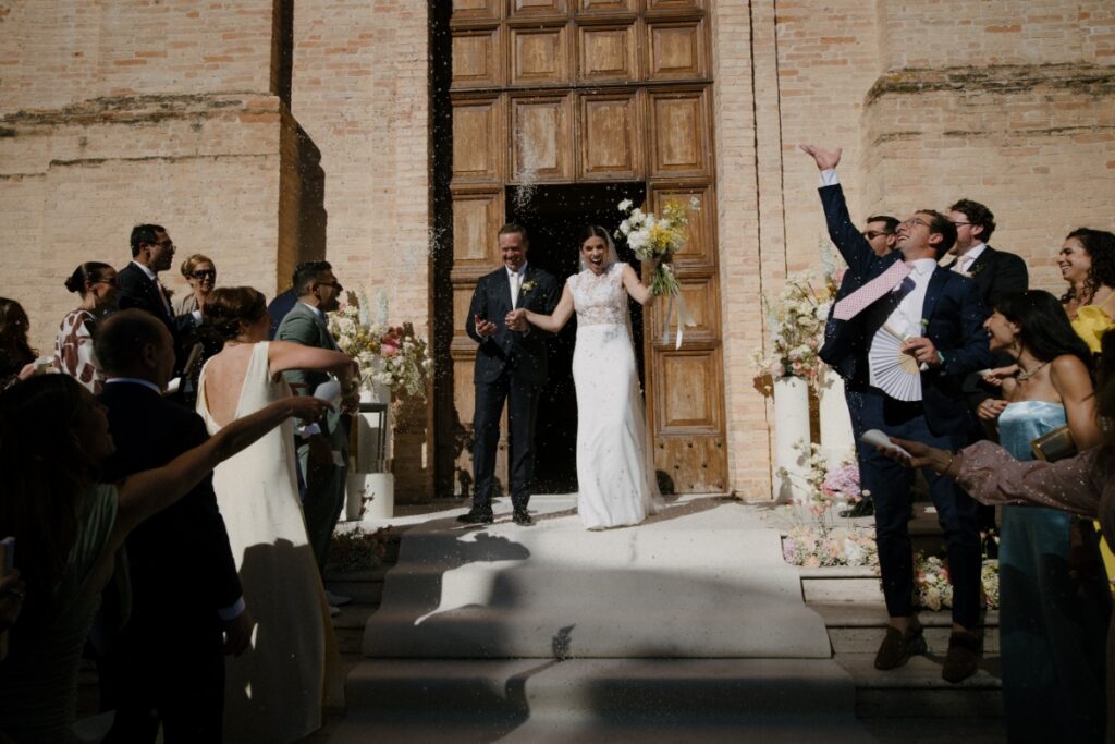 Bride Cristina Bartolacci and groom Philip Caputo exiting the church as guests throw rice to celebrate their wedding.