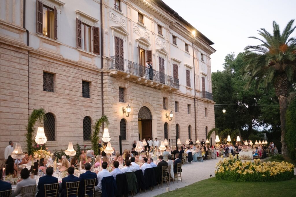 Bride Cristina Bartolacci and groom Philip Caputo wave to their guests from a stone balcony of the historic Relais Villa Corallo.