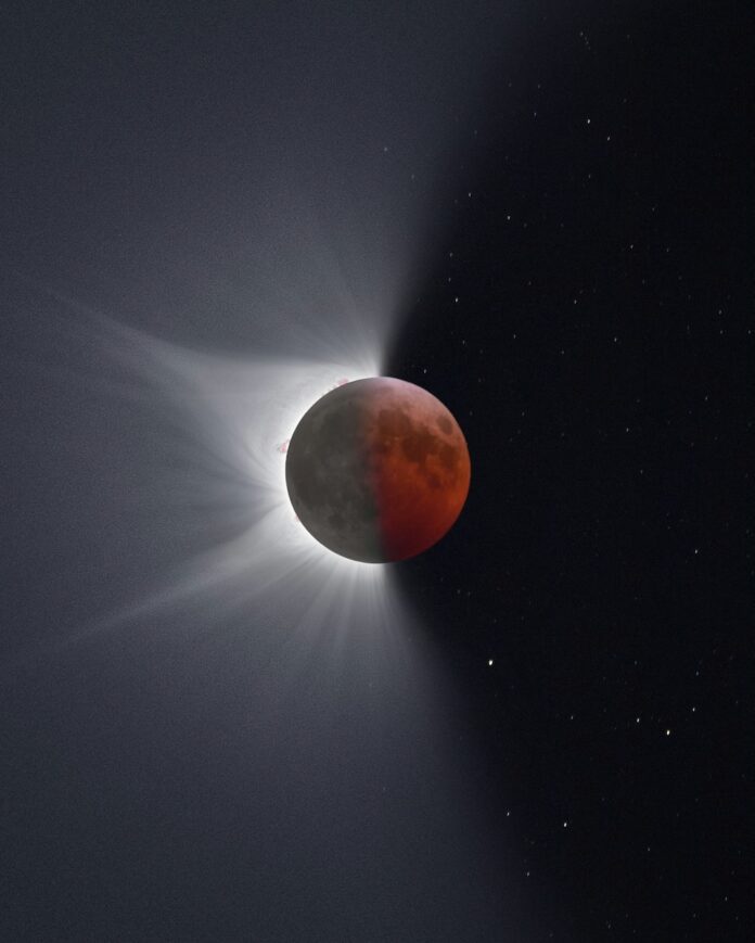 A lunar eclipse moves over a full moon in the night sky, shining light out to the left side.