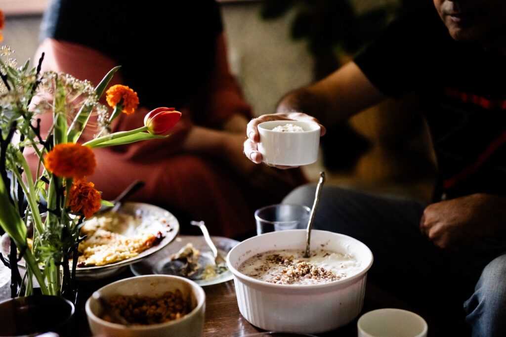 A person passes another an individual serving of Sheer Birinj Afghan Rice pudding.