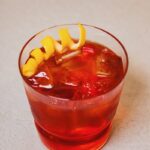 A short glass with a Norski Negroni and lemon twist garnish.