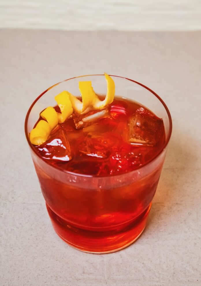A short glass with a Norski Negroni and lemon twist garnish.