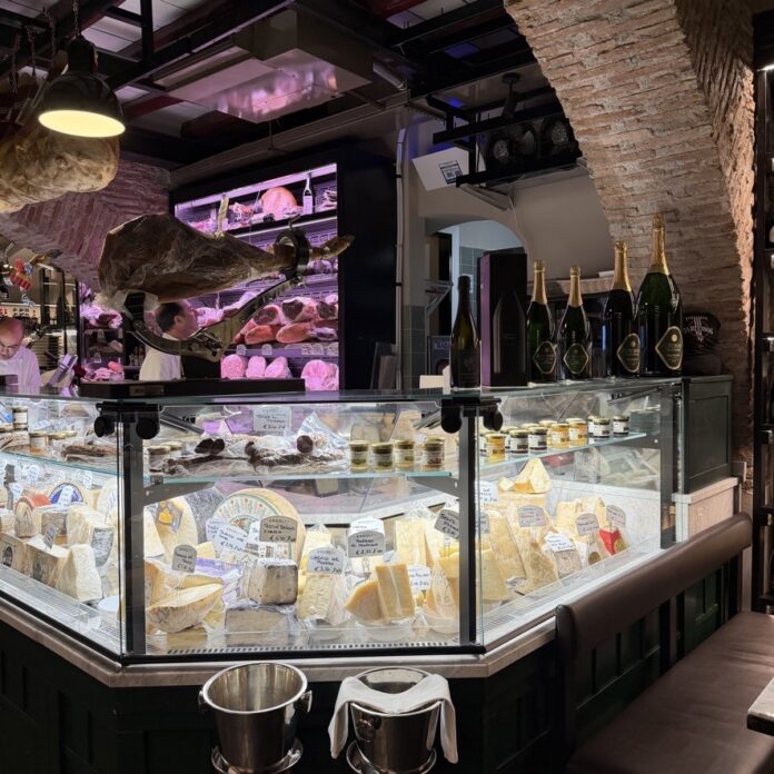 A cheese counter case filled with various cuts of cheese in Rome.