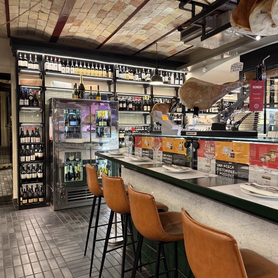 The inside counter of a bar with freezer doors behind it.