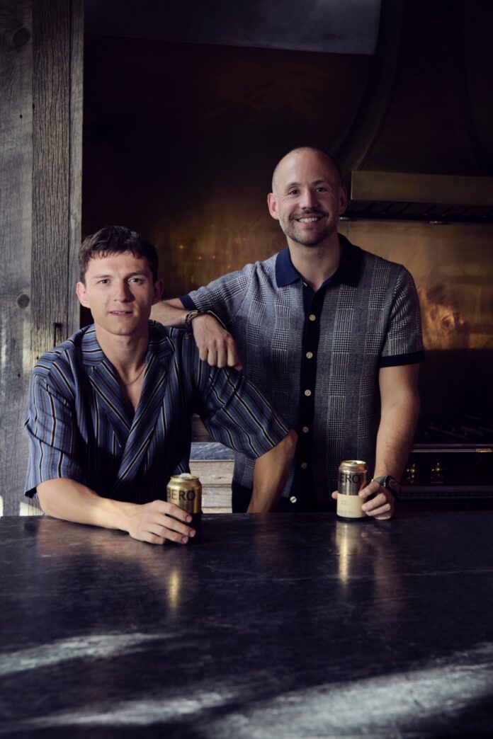 NA Drinking Trends 2026 TABLE Magazine Tom Holland and the other co-founder of BERO stand beside each other holding cans of non-alcoholic beer.