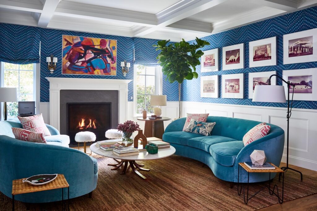 A blue couch sits actoss from another couch with the walls painted the same blue to match.