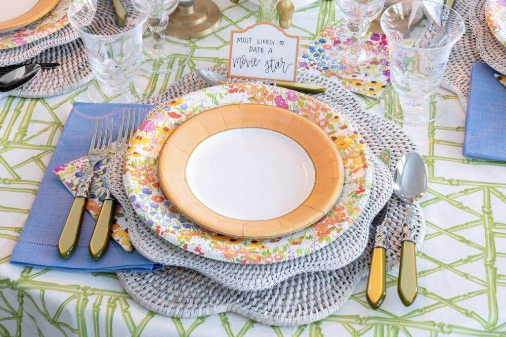 A stack of plates in florals, orange colors, and blue stripes at the bottom.