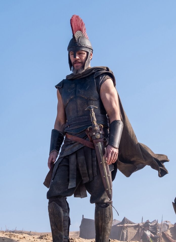 Matt Damon stands on a sandy mountain in battle gear in The Odyssey.