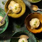 Scoops of green chile lime granita garnished with micro cilantro in small rustic ceramic bowls.