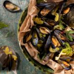 Mussels en papillote baked in parchment paper with green chile, saffron threads, and shaved fennel.