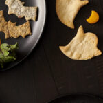 Homemade bat-shaped and ghost-shaped Halloween crackers sprinkled with sea salt.