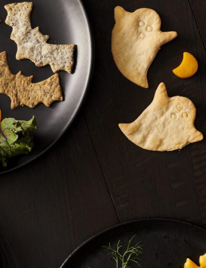 Homemade bat-shaped and ghost-shaped Halloween crackers sprinkled with sea salt.
