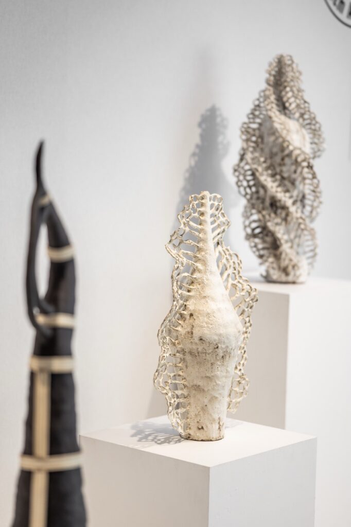 Multiple sculptures by Karlien that twist and thin out upwards in white, beige, black, and grey.