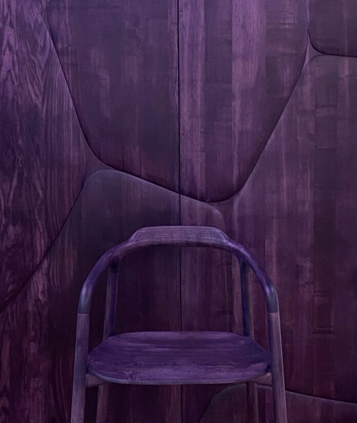 A purple chair by Franck Genser against a purple stone wall.